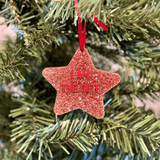 a red star ornament hanging from a christmas tree