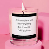 a candle with a quote on it sitting on a pink surface