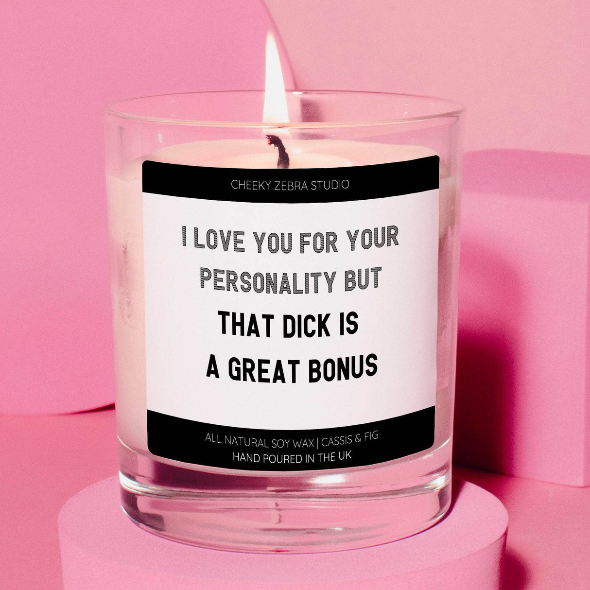 a candle with a quote on it sitting on a pink surface