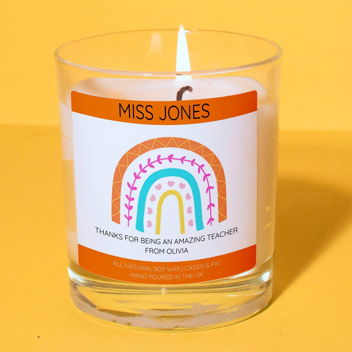 a glass candle with a rainbow on it