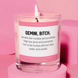 a glass candle with a pink label on it